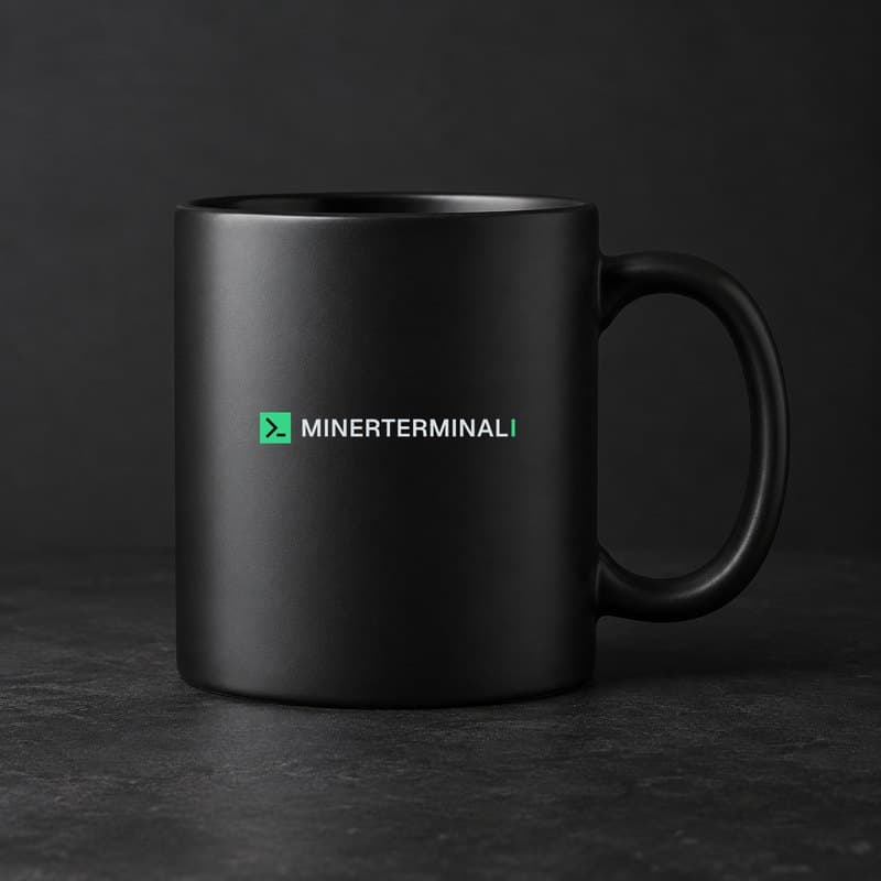 Mockup of a matte black coffee mug with the full MinerTerminal logo, the green terminal prompt mark and the wordmark